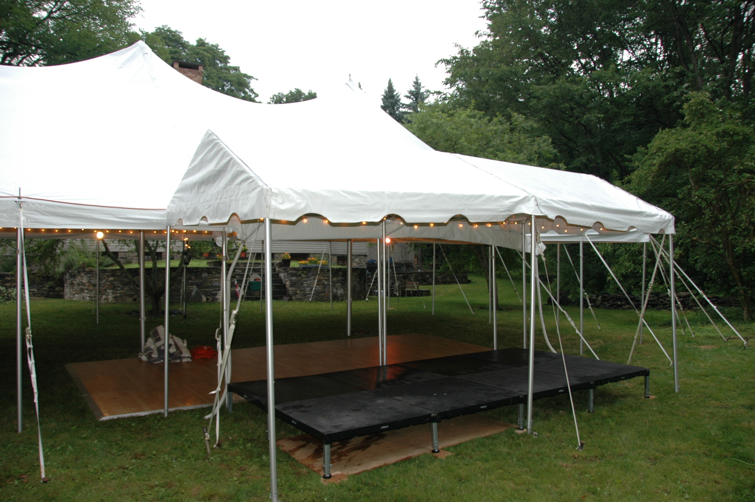Large white event tent fitted with a portable dance floor and stage